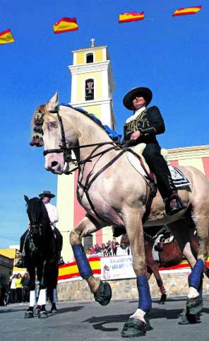 Dos jinetes, con sus monturas, en la plaza de la Iglesia